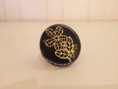 bronzen ring met zwarte achtergrond en goudkleurige afwerking